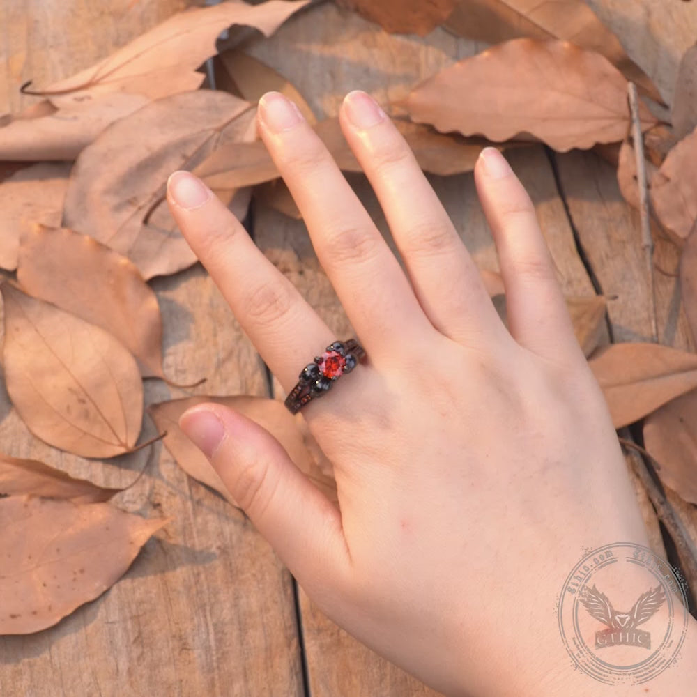 Anillo de latón con calaveras góticas y circonitas rojas